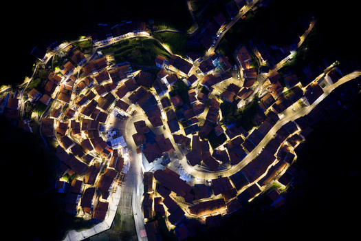 Aerial view of the illuminated coastal town of Cudillero at night with glowing streets and traditional houses nestled in the hillside Cudillero Asturias Spain. Aerial view of the illuminated coastal town of Cudillero at night with glowing streets and traditional houses nestled in the hillside Cudillero Asturias Spain.