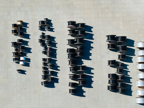 Aerial view of industrial cable spools arranged in neat rows on a concrete surface at a warehouse in Lielvarzi Kekava Municipality Latvia. Aerial view of industrial cable spools arranged in neat rows on a concrete surface at a warehouse in Lielvarzi Kekava Municipality Latvia.