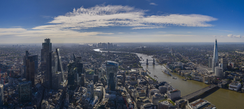 Aerial view of The Fenchurch Building and the London skyline featuring the River Thames Tower Bridge and The Shard under a blue sky London England United Kingdom. Aerial view of The Fenchurch Building and the London skyline featuring the River Thames Tower Bridge and The Shard under a blue sky London England United Kingdom.