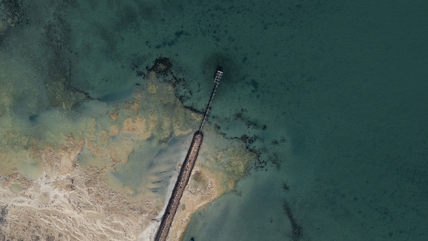 Aerial view of the turquoise waters and intricate sand patterns surrounding the jetty in Denham Western Australia Australia. Aerial view of the turquoise waters and intricate sand patterns surrounding the jetty in Denham Western Australia Australia.