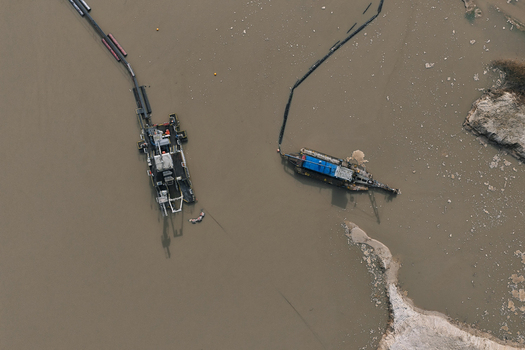 Aerial view of dredging vessels operating in a river with floating pipes and sediment deposits in Dulmen North Rhine Westphalia Germany. Aerial view of dredging vessels operating in a river with floating pipes and sediment deposits in Dulmen North Rhine Westphalia Germany.