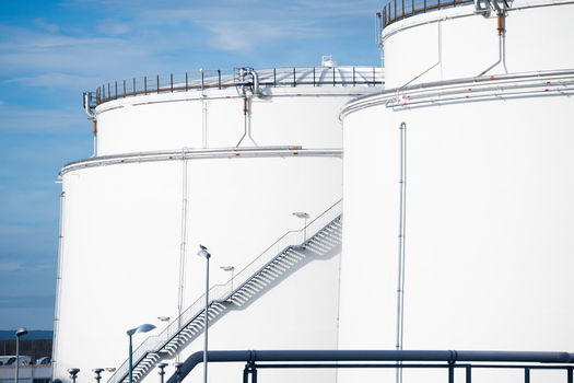 View of large white industrial storage tanks with metal staircases and piping at Frankfurt Airport in Frankfurt am Main Hessen Germany.