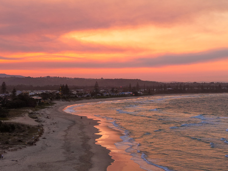 Aerial view of Kingscliff beach at sunset with golden light reflecting on the wet sand and gentle waves rolling onto the shore in Kingscliff New South Wales Australia. Aerial view of Kingscliff beach at sunset with golden light reflecting on the wet sand and gentle waves rolling onto the shore in Kingscliff New South Wales Australia.