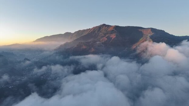 Aerial view of Dieng Plateau mountains above clouds Indonesia.