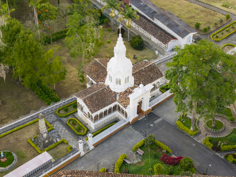 Aerial view of the Immaculate Conception Archdiocesan Sanctuary its white facade gleaming against the terracotta roofs and manicured gardens a serene landmark. Salamina Caldas Colombia. Aerial view of the Immaculate Conception Archdiocesan Sanctuary its white facade gleaming against the terracotta roofs and manicured gardens a serene landmark. Salamina Caldas Colombia.