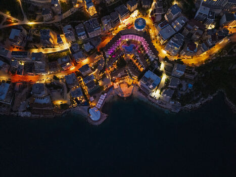 Aerial view of the illuminated coastal city of Saranda at night featuring glowing hotels vibrant street lights and a swimming pool along the shoreline in Saranda Vlore County Albania. Aerial view of the illuminated coastal city of Saranda at night featuring glowing hotels vibrant street lights and a swimming pool along the shoreline in Saranda Vlore County Albania.