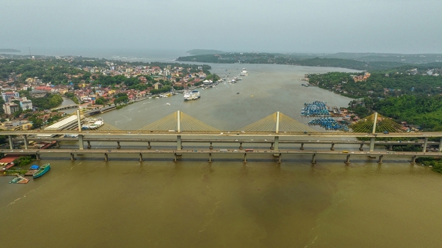 Aerial view of Atal Setu Goa a cable stayed bridge spanning the Mandovi River with urban Panaji in the background lush greenery and boats on the water in Panaji Goa India.