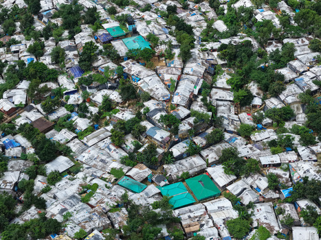 Aerial view of Camp 7 Kutupalang Expansion Sites featuring dense makeshift shelters with tarpaulin roofs and scattered trees in Cox s Bazar District Chittagong Division Bangladesh.