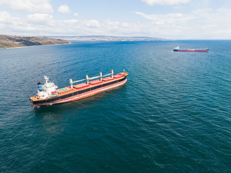 Aerial view of large cargo ships anchored in the deep blue waters of the Black Sea near the coastline under a bright sky with scattered clouds Varna Varna Bulgaria. Aerial view of large cargo ships anchored in the deep blue waters of the Black Sea near the coastline under a bright sky with scattered clouds Varna Varna Bulgaria.