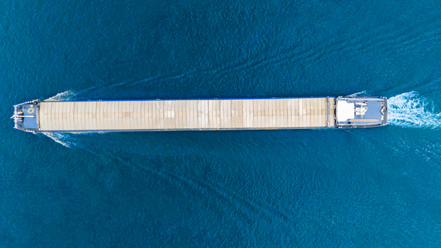 Aerial view of a long industrial cargo barge cruising through the deep blue water of the Danube river in Novi Sad Vojvodina Serbia. Aerial view of a long industrial cargo barge cruising through the deep blue water of the Danube river in Novi Sad Vojvodina Serbia.