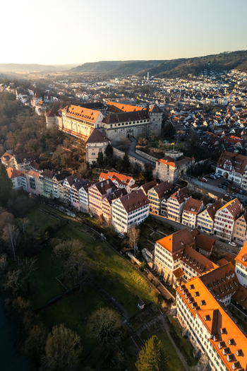 Aerial view of Hohentubingen Castle and the historic old town with traditional half timbered houses along the river bank during sunset in Tubingen Baden Wurttemberg Germany.