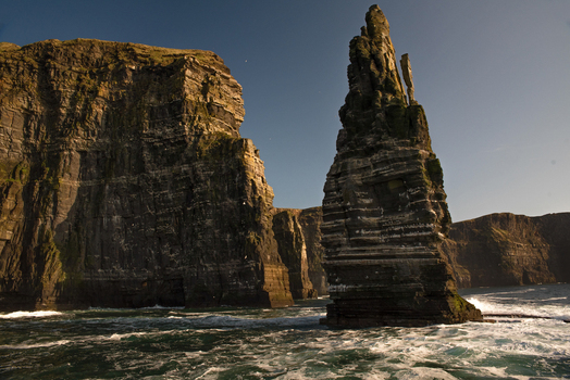 View of the majestic Cliffs of Moher and the Branaunmore sea stack rising from the Atlantic Ocean under a clear sky County Clare Ireland. View of the majestic Cliffs of Moher and the Branaunmore sea stack rising from the Atlantic Ocean under a clear sky County Clare Ireland.