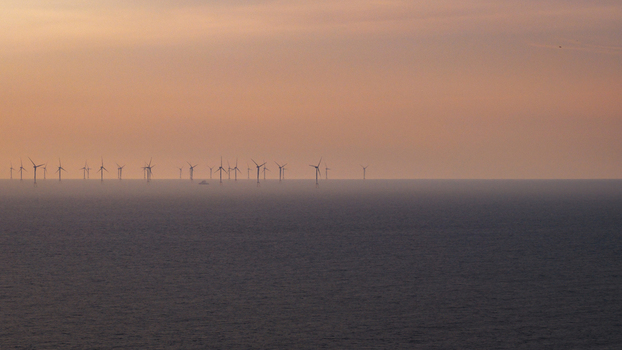 Aerial view of wind turbines in the Atlantic Ocean during sunset off the coast of Plevenon Brittany France. Aerial view of wind turbines in the Atlantic Ocean during sunset off the coast of Plevenon Brittany France.