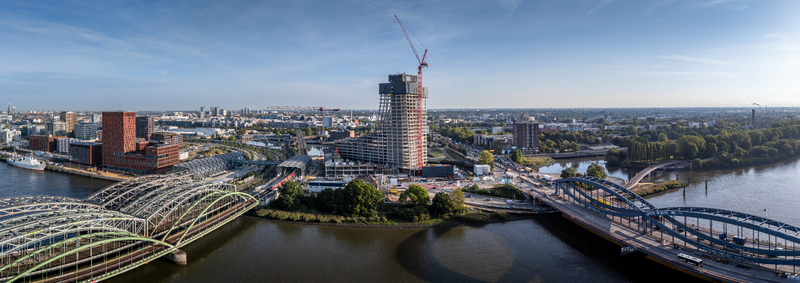 Aerial view of Elbbrucken bridges in Hamburg featuring modern construction steel arch bridges and the Elbe river under a clear blue sky in Hamburg Germany.