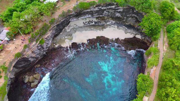 Aerial view of Broken Beach with turquoise water and rocky cliffs Indonesia.