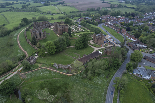Aerial view of Kenilworth Castle and Elizabethan Garden surrounded by green fields historic stone ruins and lush trees in Kenilworth England United Kingdom.