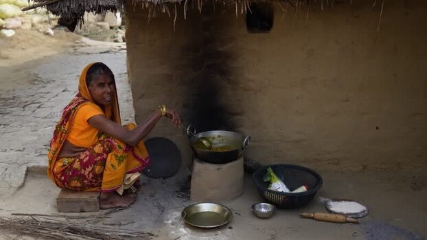 View of an Indian woman cooking on a traditional clay stove India.