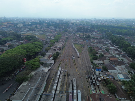 Aerial view of Stasiun Malang Kota Baru with railway tracks trains and surrounding urban landscape in Kecamatan Klojen Jawa Timur Indonesia.