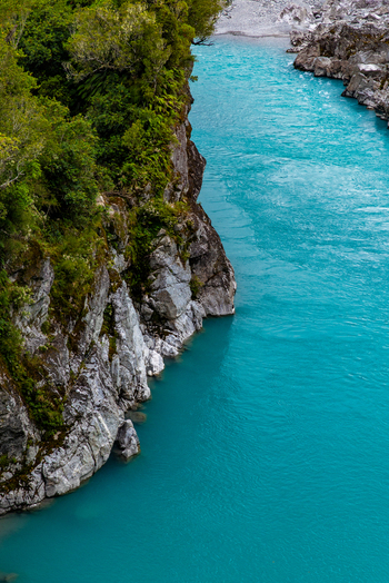 Aerial view of the turquoise river carving its way through the rugged rocky terrain framed by verdant cliffs Hokitika Gorge New Zealand. Aerial view of the turquoise river carving its way through the rugged rocky terrain framed by verdant cliffs Hokitika Gorge New Zealand.