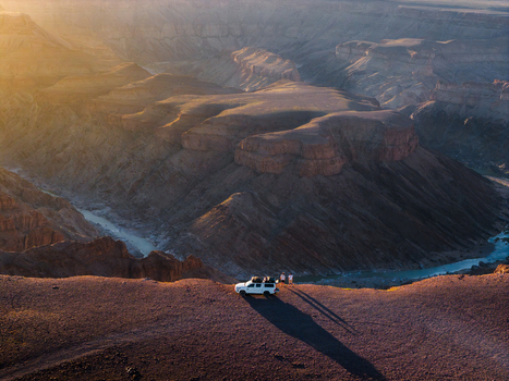 Aerial view of the stark rugged Fish River Canyon reveals a dramatic landscape carved by time with warm light painting the cliffs Fish River Canyon Karas Region Namibia. Aerial view of the stark rugged Fish River Canyon reveals a dramatic landscape carved by time with warm light painting the cliffs Fish River Canyon Karas Region Namibia.