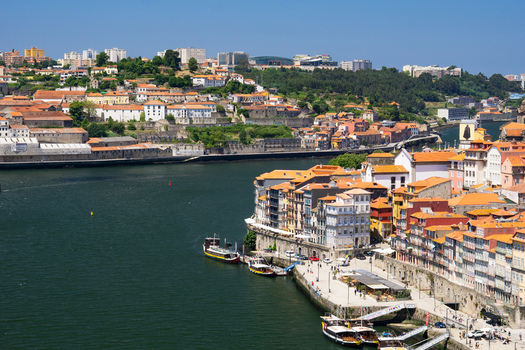 Aerial view of terracotta rooftops cascade down to the riverfront reflecting the warm Portuguese sun Porto Porto District Portugal. Aerial view of terracotta rooftops cascade down to the riverfront reflecting the warm Portuguese sun Porto Porto District Portugal.