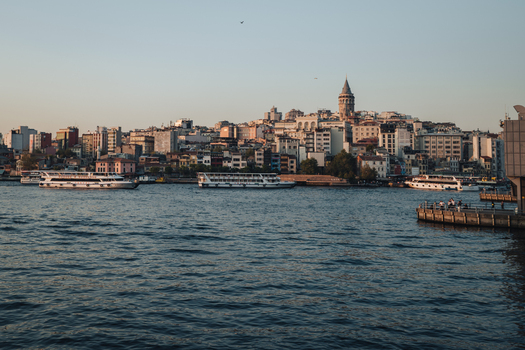 Istanbul Turkiye 02 October 2019 View of the Galata Tower piercing the skyline above the European side with boats gliding on the Bosphorus waters.