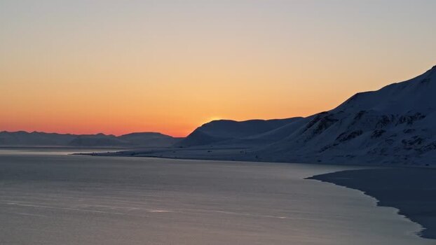 Aerial view of sunset over snowy mountains in Svalbard and Jan Mayen. Aerial view of sunset over snowy mountains in Svalbard and Jan Mayen.