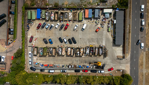 Aerial view of Stevenage Recycling Centre with rows of waste containers and parked cars on an asphalt surface in Stevenage England United Kingdom.