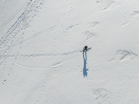 Aerial view of the south slope of Mount Etna with a person ski touring across the snow with long shadows in Nicolosi Sicilia Italy. Aerial view of the south slope of Mount Etna with a person ski touring across the snow with long shadows in Nicolosi Sicilia Italy.