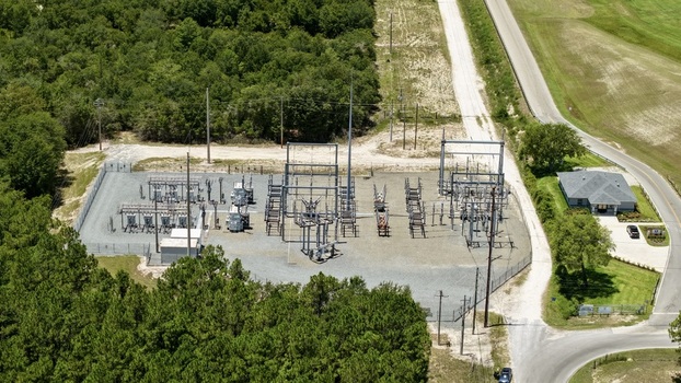 Aerial view of the Georgia Pacific Palatka Operations electrical substation featuring industrial equipment and metal structures surrounded by dense forest in Palatka Florida United States.