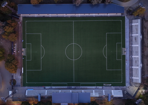 Aerial view of Mladost Sports Center with its green soccer field white pitch markings and surrounding stadium seating in Pancevo Serbia. Aerial view of Mladost Sports Center with its green soccer field white pitch markings and surrounding stadium seating in Pancevo Serbia.