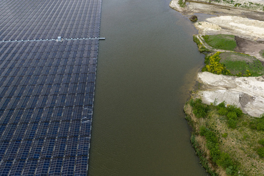 Aerial view of a large floating solar farm on a calm lake next to a sandy shoreline with green vegetation Beilen Drenthe Netherlands. Aerial view of a large floating solar farm on a calm lake next to a sandy shoreline with green vegetation Beilen Drenthe Netherlands.