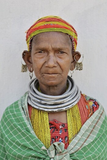 Odisha India 26 March 2026 View of an indigenous woman adorned with stacked silver necklaces large earrings and a vibrant striped headwrap against a stark white backdrop. Odisha India 26 March 2026 View of an indigenous woman adorned with stacked silver necklaces large earrings and a vibrant striped headwrap against a stark white backdrop.