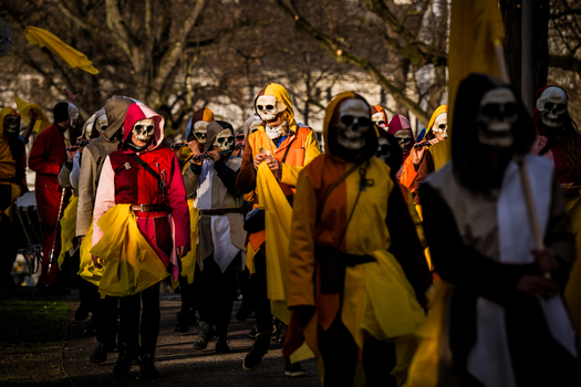 Basel Switzerland 10 March 2025 View of a parade of masked figures in vibrant costumes a river of color and movement against the muted backdrop of trees. Basel Switzerland 10 March 2025 View of a parade of masked figures in vibrant costumes a river of color and movement against the muted backdrop of trees.