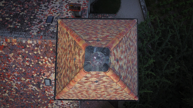 Aerial view of the colorful patterned tile roof of the historic Temple de Luins tower with mosaic shingles in Luins Vaud Switzerland. Aerial view of the colorful patterned tile roof of the historic Temple de Luins tower with mosaic shingles in Luins Vaud Switzerland.