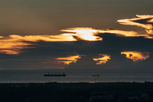 Chattogram Bangladesh 01 September 2021 Aerial view of ships sailing on the sea during a dramatic golden sunset with dark clouds over the horizon.