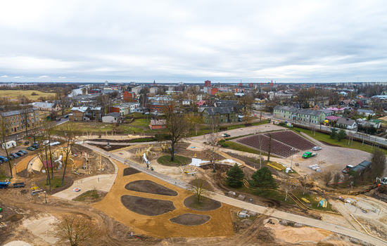 Aerial view of a park under construction with new pathways landscaped soil areas and surrounding urban buildings in Latvia. Aerial view of a park under construction with new pathways landscaped soil areas and surrounding urban buildings in Latvia.