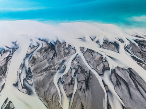 Aerial view of braided rivers interweaving with glacial sediments create a tapestry of grey against turquoise water Lake Tekapo Canterbury Region New Zealand. Aerial view of braided rivers interweaving with glacial sediments create a tapestry of grey against turquoise water Lake Tekapo Canterbury Region New Zealand.