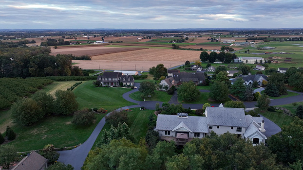 Aerial view of Warwick Township in autumn featuring residential houses manicured lawns and surrounding agricultural fields in Rothsville Pennsylvania United States.