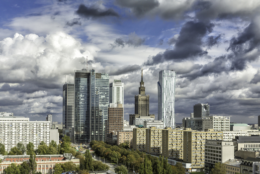 Aerial view of the Warsaw skyline featuring the Palace of Culture and Science with modern skyscrapers and residential blocks under a cloudy sky in Warsaw Masovian Voivodeship Poland. Aerial view of the Warsaw skyline featuring the Palace of Culture and Science with modern skyscrapers and residential blocks under a cloudy sky in Warsaw Masovian Voivodeship Poland.