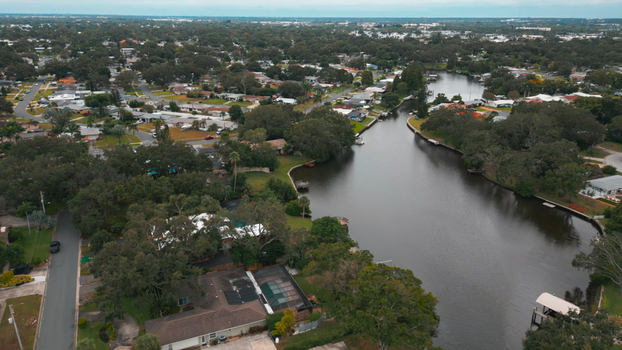 Aerial view of a residential neighborhood with houses lush trees and a winding canal in Clearwater Florida United States.