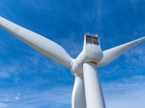 Aerial view of a white wind turbine against a clear blue sky in Lakeshore Ontario Canada. Aerial view of a white wind turbine against a clear blue sky in Lakeshore Ontario Canada.