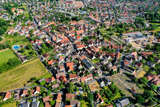 Aerial view of the historic town center featuring traditional red roofed houses a church spire and green fields in Neunkirchen am Brand Bavaria Germany. Aerial view of the historic town center featuring traditional red roofed houses a church spire and green fields in Neunkirchen am Brand Bavaria Germany.