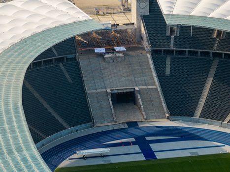 Berlin Germany 26 September 2026 Aerial view of Olympiastadion Berlin showing the iconic blue running track tiered seating and the distinctive roof structure under clear daylight.