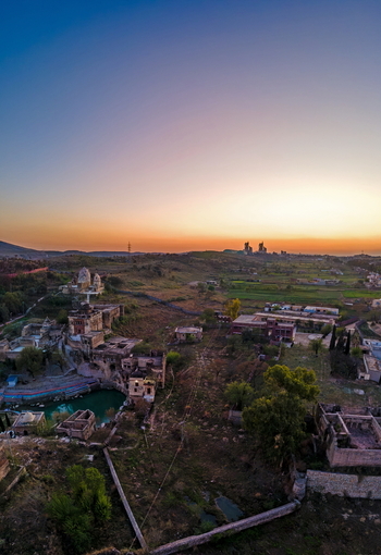 Aerial view of Katas Raj Temple Complex featuring ancient Hindu temples a sacred pond and surrounding rural landscape at sunset in Katas Punjab Pakistan. Aerial view of Katas Raj Temple Complex featuring ancient Hindu temples a sacred pond and surrounding rural landscape at sunset in Katas Punjab Pakistan.