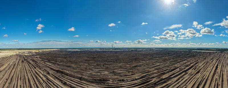 Aerial view of Tagebau Welzow Sud brown coal open pit mine showing vast excavated earth layers industrial landscape and clear blue sky in Spremberg Brandenburg Germany. Aerial view of Tagebau Welzow Sud brown coal open pit mine showing vast excavated earth layers industrial landscape and clear blue sky in Spremberg Brandenburg Germany.