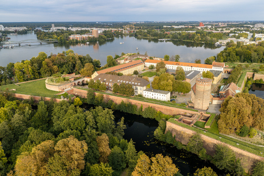 Aerial view of Spandau Citadel featuring historic brick fortifications a central tower surrounding lush trees and the Havel river in Berlin Berlin Germany.