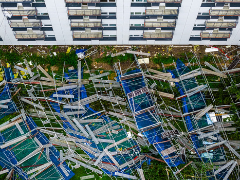 Riga Latvia 23 August 2026 Aerial view of collapsed scaffolding and construction materials scattered on the ground next to a modern apartment building with balconies.