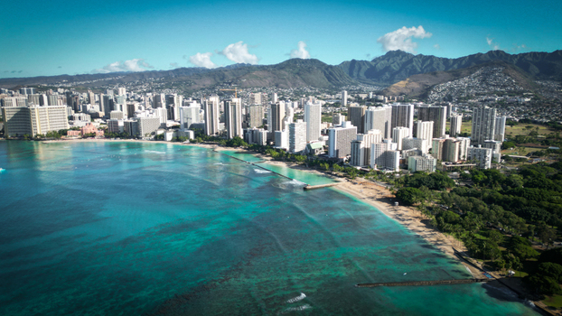 Aerial view of Waikiki Beach s turquoise waters meeting the sandy shore backed by the bustling city skyline and distant mountains Honolulu Hawaii United States. Aerial view of Waikiki Beach s turquoise waters meeting the sandy shore backed by the bustling city skyline and distant mountains Honolulu Hawaii United States.