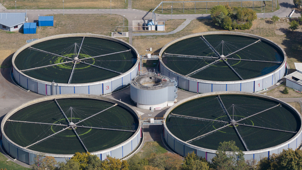 Aerial view of the Klarwerk Karlsruhe wastewater treatment plant featuring four large circular sedimentation tanks with mechanical arms in Karlsruhe Baden Wurttemberg Germany.